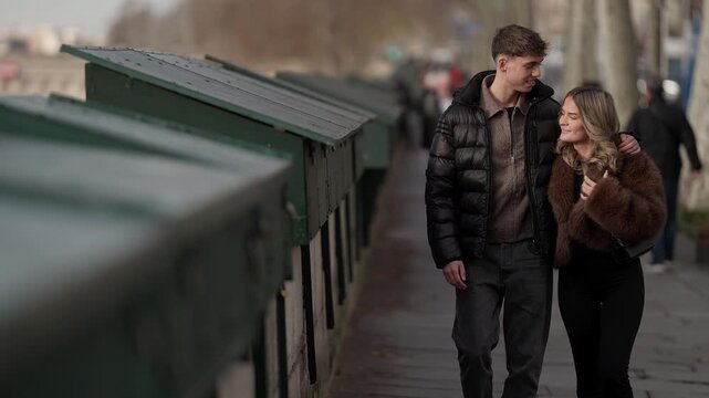 A couple walks along the Seine River in Paris France The romantic stroll takes place along the riverbank with the Eiffel Tower visible in the distance The clip embodies travel love and a modern lifest