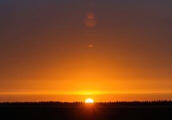 Fototapeta premium Brilliant golden and fiery orange light illuminates the tranquil morning sky as the sun ascends above the distant horizon line ,new day ,red ,natural