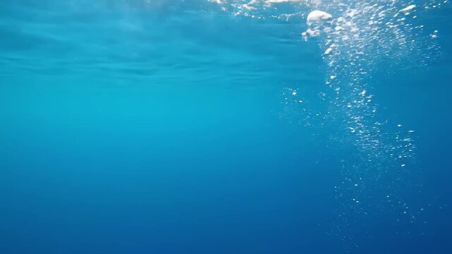 Air Bubbles Rising in Deep Blue Ocean Water