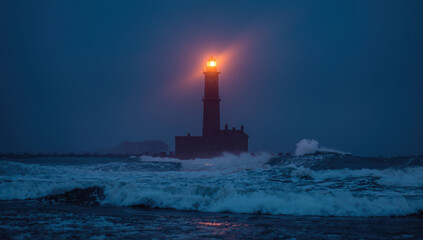 Fototapeta premium Lighthouse beacon glowing over stormy sea at dusk, dramatic moody scene