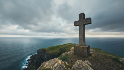 Stone cross on coastal cliff overlooking dramatic ocean and cloudy sky
