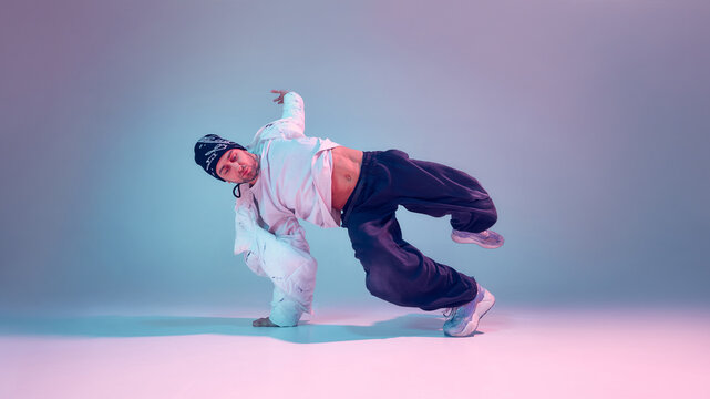 Breakdancer performing power move with dramatic lighting. Concept of sports performance marketing, dance competition promotion, strength focused training visuals and urban culture advertising.
