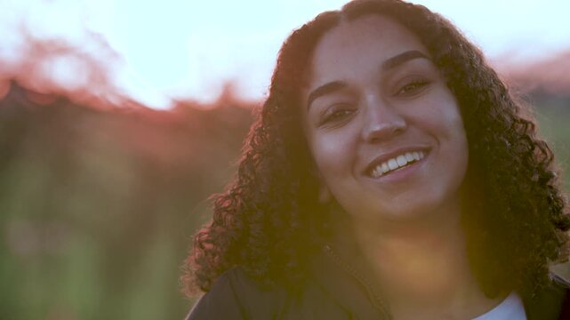 Beautiful mixed race African American girl teenager young woman backlit by the sun in evening sunshine