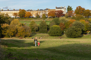 Mother and child in Petersham Meadows with Richmond Hill and Terrace Gardens in the background