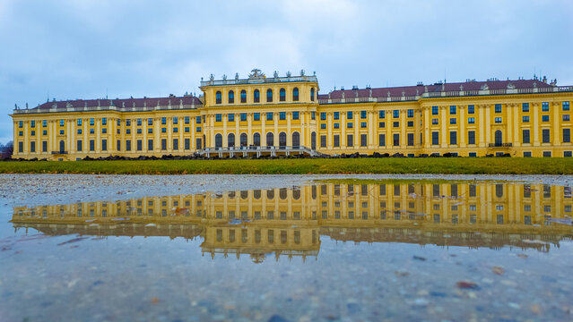 Vienna, Austria - December 14, 2024: Schonbrunn Palace or Schloss Schoenbrunn in Wien, is an imperial summer residence. Schonbrunn Palace is a major tourist attraction. Amazing reflection.