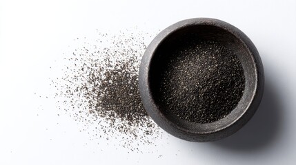 iron bowl with heap of finely ground black pepper, top view, isolated, food and seasoning concept