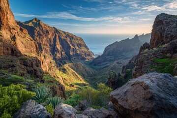 Fototapeta premium Sunlit Masca Canyon in Tenerife: limestone cliffs, winding river and lush gorge