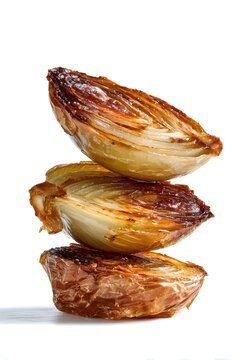 Stack of roasted golden brown shallots or onions on white background, caramelized grilled vegetable halves, isolated