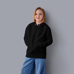 Mockup of a black hoodie on a girl in blue jeans, front view, isolated on a background.
