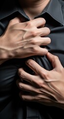 Obraz premium Tension anxiety grip to clutch hand stress A close-up hands gripping a dark shirt over the chest conveying intense emotion and physical strain