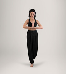 Mockup of black wide pants for yoga, top on trainer, beautiful woman in sportswear, front view in full height, isolated on background.