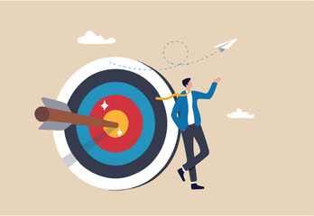 Business objective, purpose or target, goal and resolution to aim for success, aspiration and motivation to achieve goal concept, confident businessman stand with arrow hit bullseye on archery target