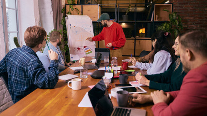 Group of coworkers discussing tasks in modern office. Concept of task coordination, daily workflow...