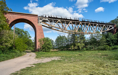 The metal structure of a destroyed railway viaduct against the sky
