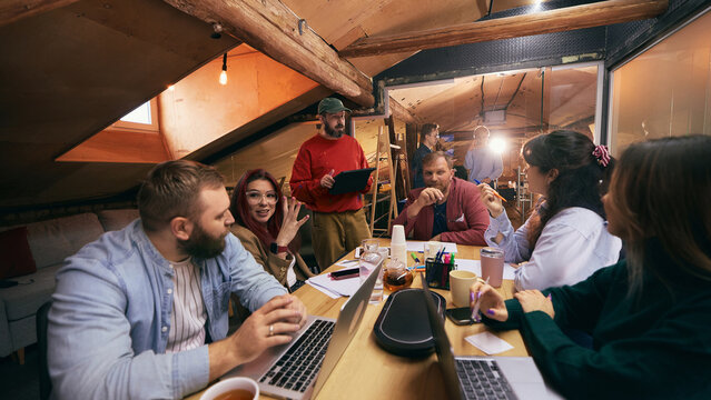 Creative professionals collaborating during startup meeting indoors. Concept of teamwork, business communication, innovation process, and modern office collaboration. - Powered by Adobe