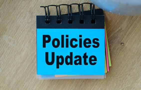 A blue spiral bound notebook with the word Policies Update written on it.