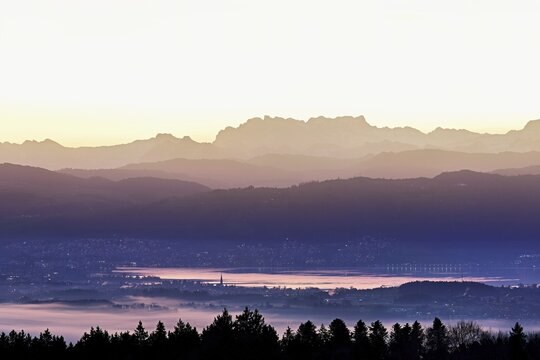 View from Horben of Lake Zug with the town of Cham and Zug, behind it the snow-capped mountains Fl&uuml;brig and Vrenelisg&auml;rtli in the light of dawn, Beinwil-Freiamt, Canton, Aargau, Switzerland