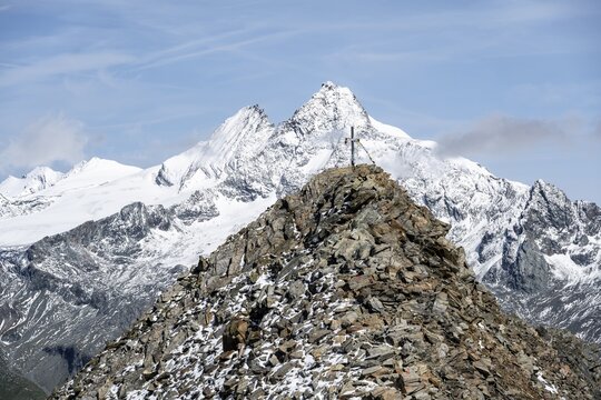 Summit cross of the summit B&ouml;ses Weibl, behind summit of the Gro&szlig;glockner with snow, Schober group, Hohe Tauern National Park, Carinthia, Austria