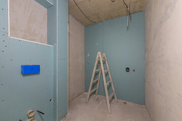 Bathroom Renovation in Progress with Moisture-Resistant Drywall Installation. Interior construction site showing home improvement, remodeling, and concealed toilet system framing.