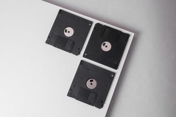 Retro black plastic floppy disks on a white background