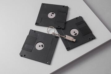 Retro floppy disks and modern flash drive on a light background