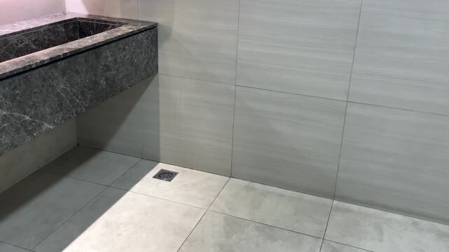 A row of automatic faucets in a luxurious bathroom with a marble sink.