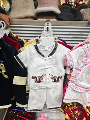 Naklejka premium chinese colorful cultural children clothes for sale at market. vertical
