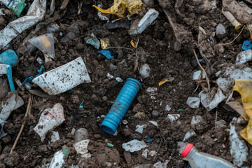 Plastic waste scattered in soil highlighting environmental pollution microplastic problem and human impact on nature