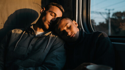Young couple sleeping on train journey together.