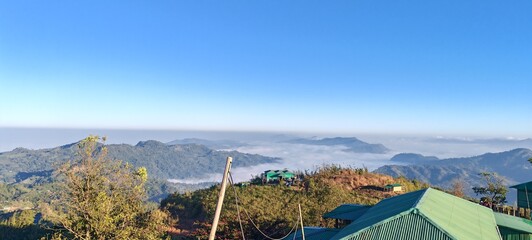 Dramatic cloud sea over green mountains, scenic natural landscape