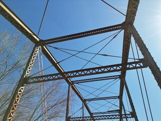 Looking up at a  Parker truss bridge that was built in 1897 and 1898. It is on the historic National Register of Historic Places, added in 1998. This is the Sufliff Bridge in Iowa. 