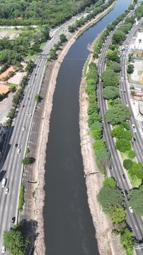 Filmagem a&eacute;rea da Marginal Tiet&ecirc; destacando fluxo cont&iacute;nuo de ve&iacute;culos, mobilidade urbana e integra&ccedil;&atilde;o com &aacute;reas urbanizadas da cidade de S&atilde;o Paulo.