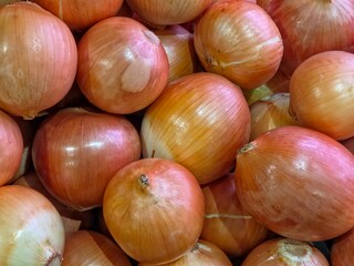 A cluster of yellow onions packed tightly together.