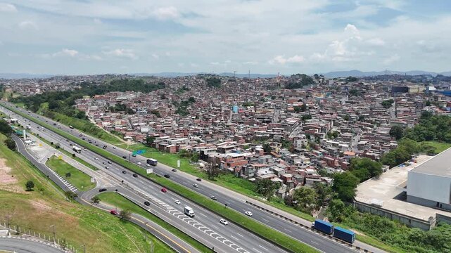 Vis&atilde;o a&eacute;rea mostra favela ao lado de rodovia, revelando desigualdades urbanas em Guarulhos, S&atilde;o PAulo