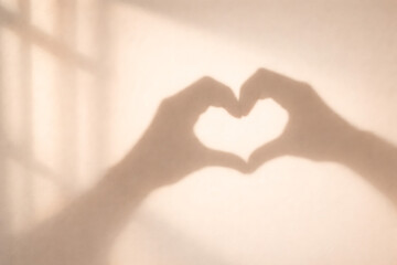 Hands forming heart shape with fingers on sunny background