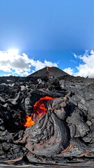 Molten lava flows up a volcanic slope under a bright sky