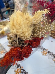Natural dried flowers bouquet with wheat, lagurus and red plants, rustic floral decor background.