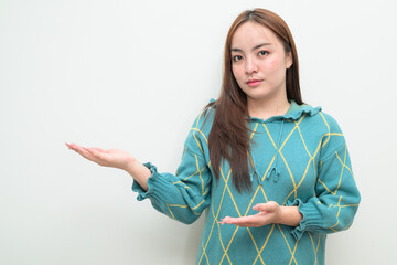 Portrait of a young Asian woman against white background showing copy space