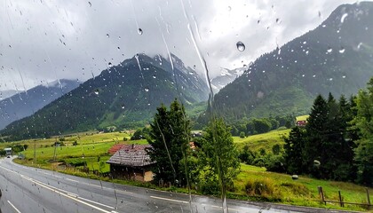 Mountain landscape view through rain-streaked window