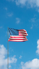 Fototapeta premium Flag United States against cloudy sky. USA flag waving in the wind, national symbol. Country, nation, union, flag, US government, american culture, politics.