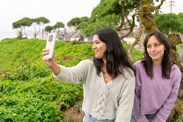Obraz premium Young women creating social media content outdoors