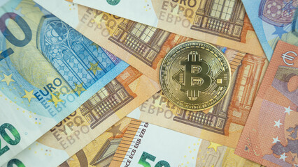 Bitcoin coin on euro banknotes background.