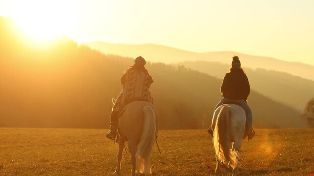 Two women riding horses toward the sunset across an open meadow, calm atmosphere and shared equestrian freedom
