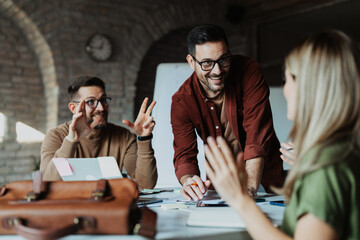 Diverse startup team collaborating on a new project in a modern, open-plan office with a creative atmosphere