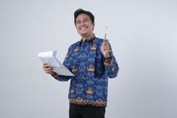 Indonesian male civil servant teacher wearing PNS batik uniform reading a document with a surprised...