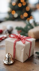 A red gift box is placed on a wooden table surrounded by Christmas decorations and a candy cane