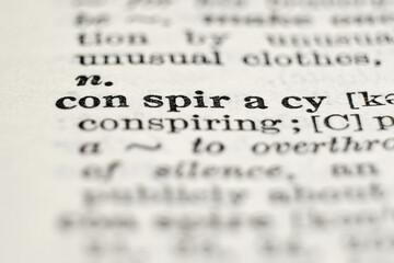 Macro photo of “conspiracy” on a dictionary page, concept for secret plots, politics and crime.