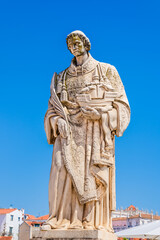 Fototapeta premium Statue of St Vincent of Saragossa or Sao Vicente de Fora, patron saint of the city, holding a boat with 2 ravens (symbols of Lisbon), at the lookout Miradouro Portas do Sol in Alfama, Lisbon, Portugal