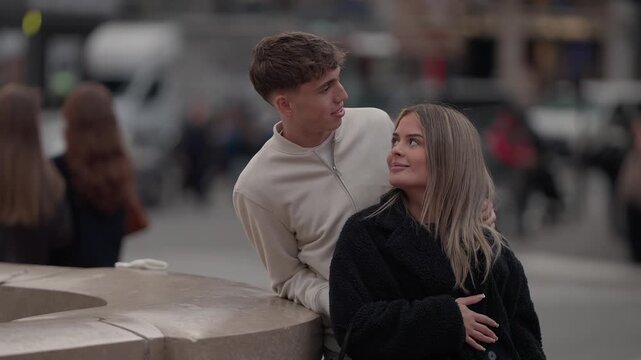 A young couple in love is seen in Paris France The man and woman are looking at each other in an urban setting with a blurred background The clip captures a moment of romance and connection in the cit