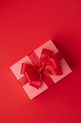 Gift Box With Red Ribbon on Bright Red Background Ready for Celebration